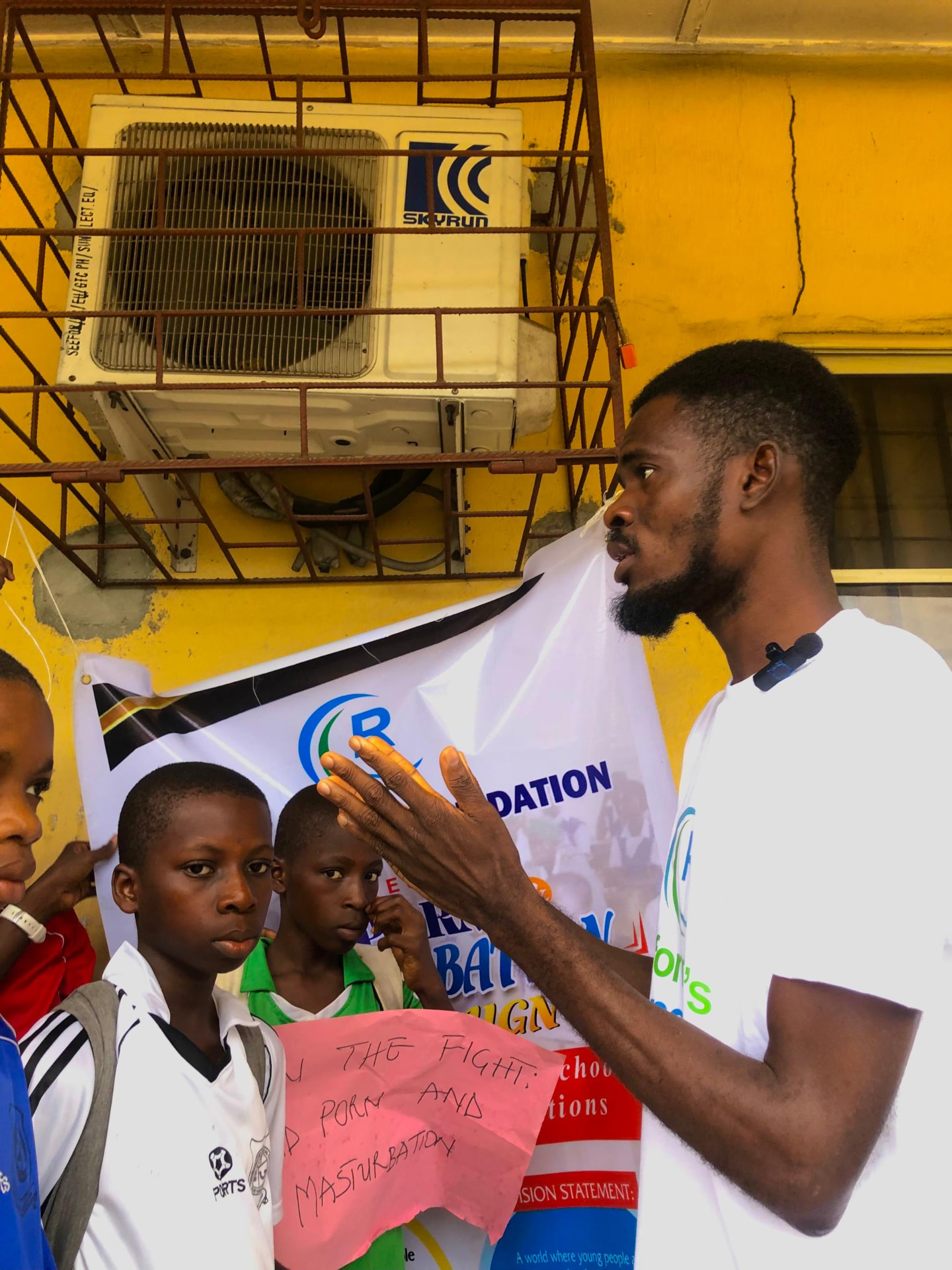 Facilitator speaking with young students at a campaign event