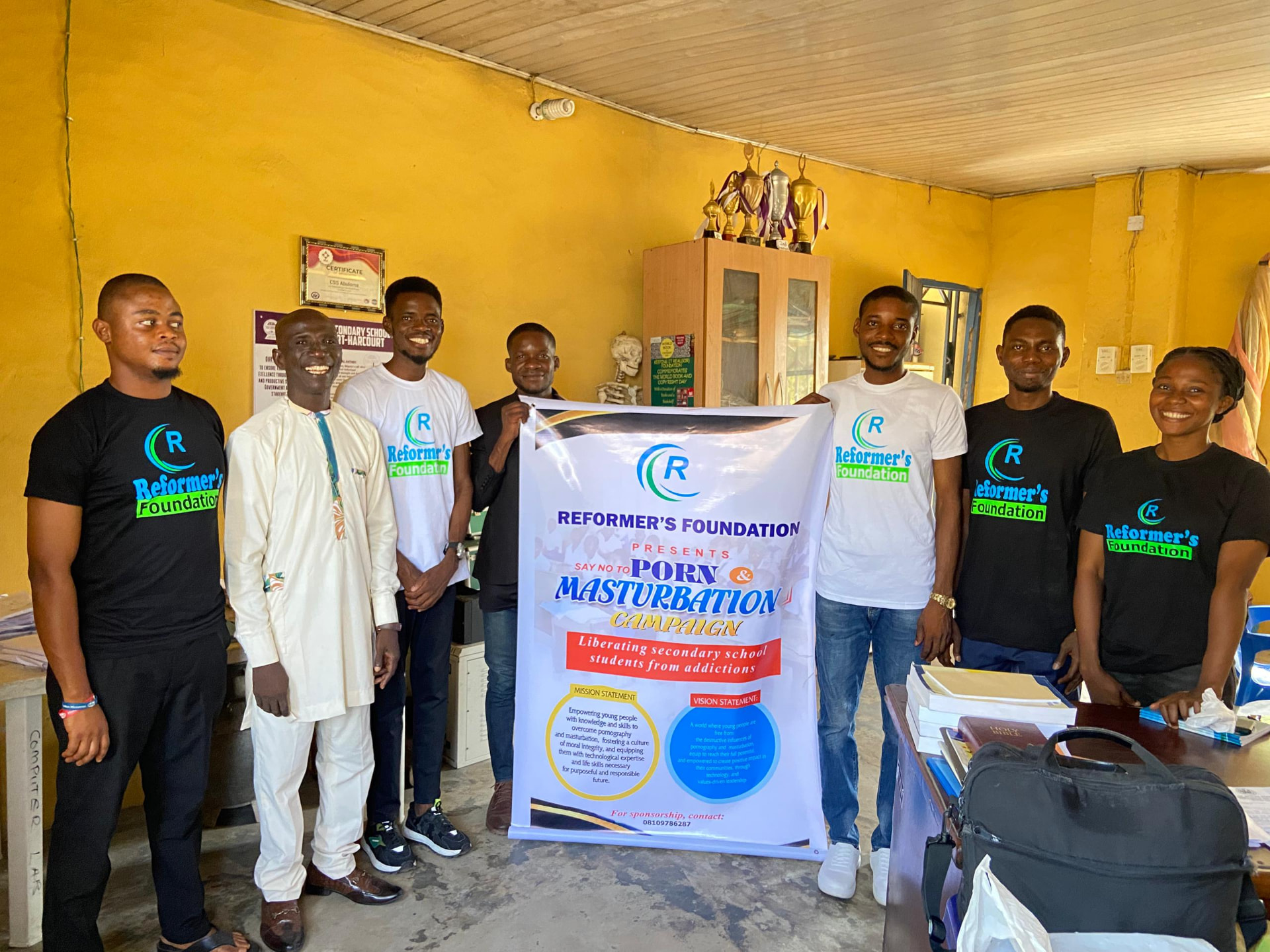 Reformer's Foundation team presenting the campaign banner at a secondary school