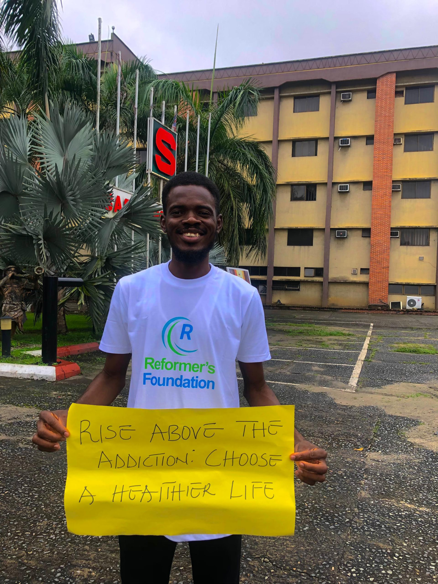 Volunteer holding a Rise Above the Addiction placard