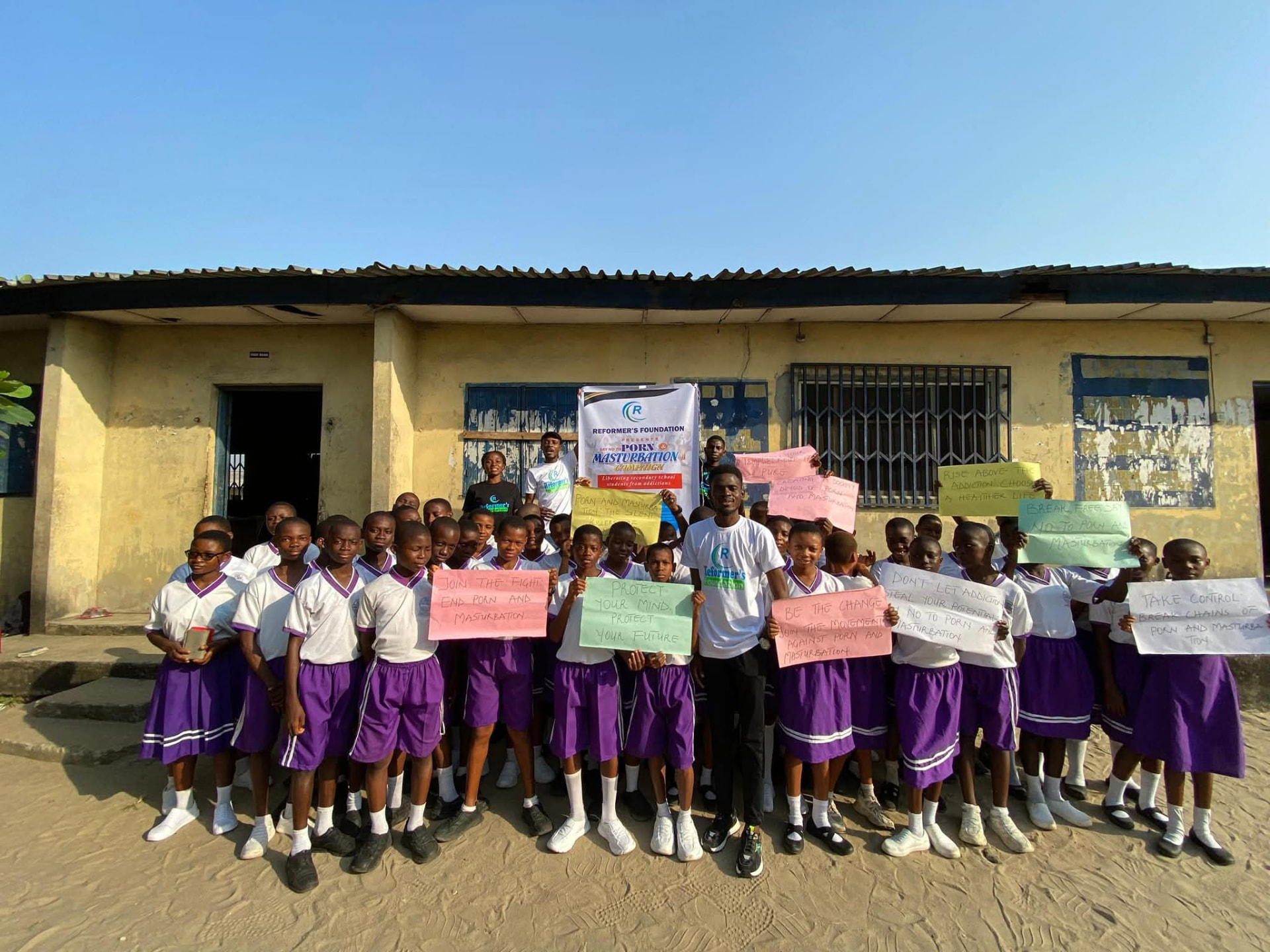 Students holding campaign placards at a Reformer's Foundation school outreach